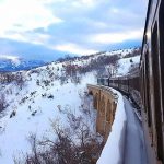 treno storico su ponte nella neve transiberiana
