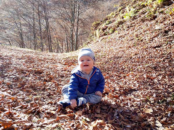 bambino tra le foglie in autunno