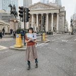Donna per le strade di Londra con il libro di mary Poppins
