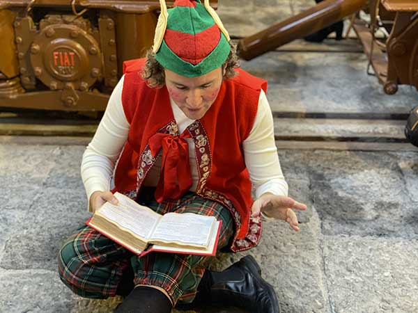 elfo di Natale legge un libro 