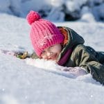 bambino ride con la faccia sulla neve