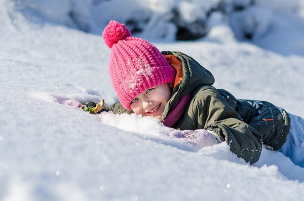 bambino ride con la faccia sulla neve