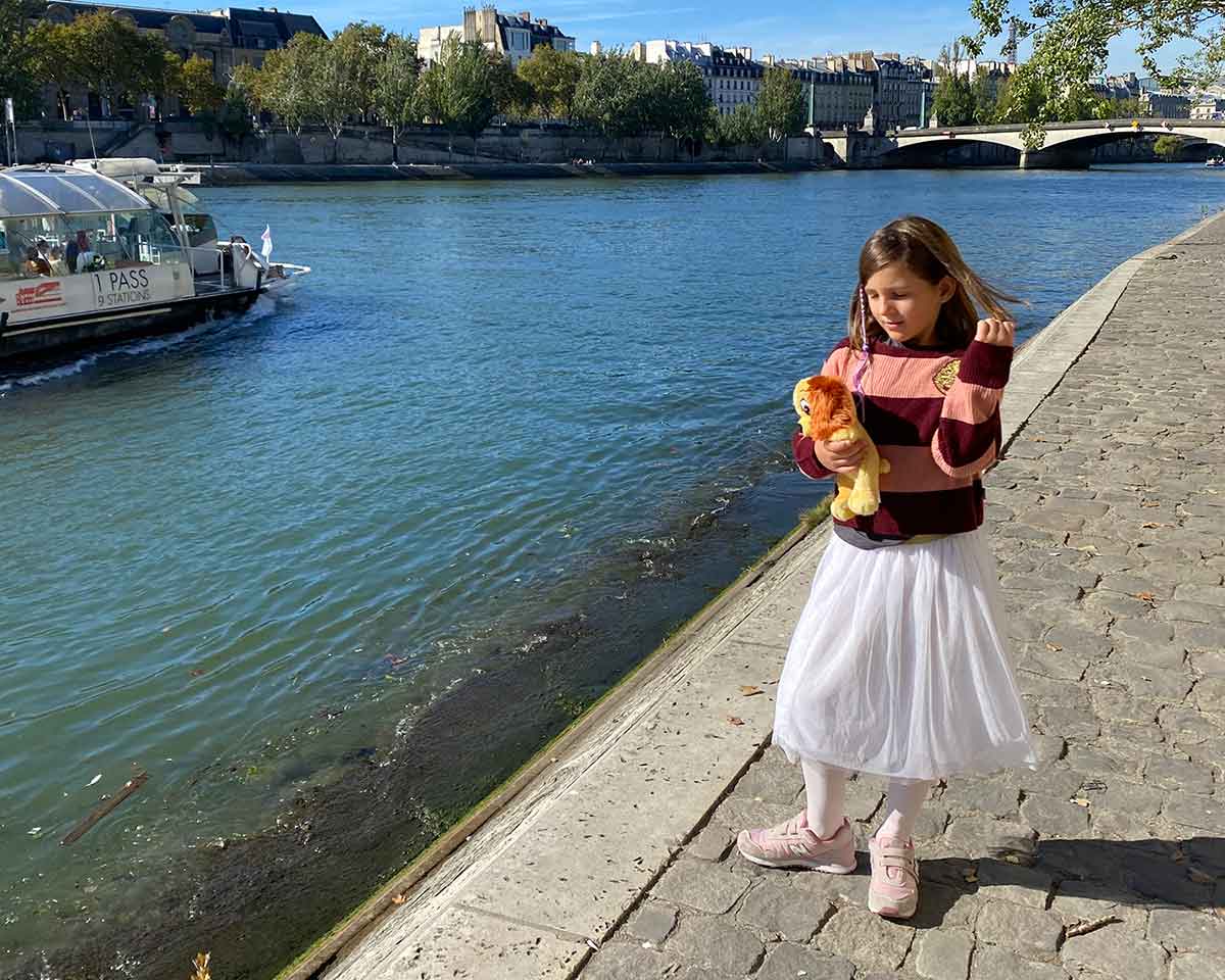 parigi con i bambini; bambina cammina lungo la Senna