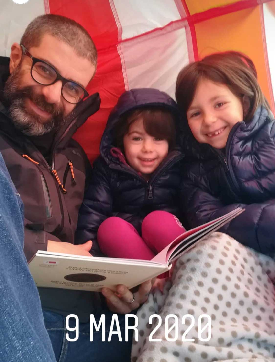 famiglia legge libro in tenda