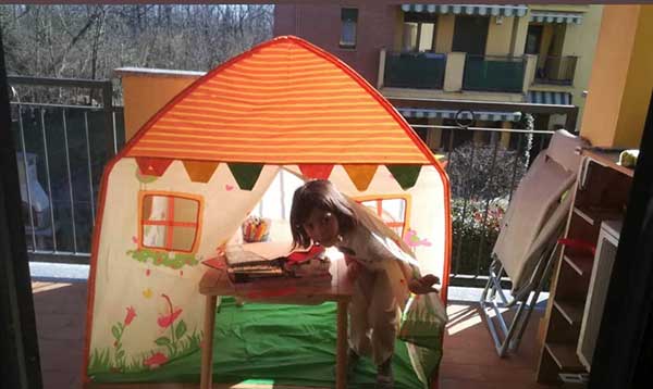 bambina in una tenda sul balcone