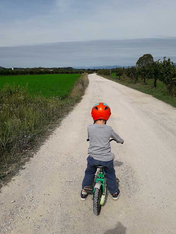 bambino in bici con casco rosso