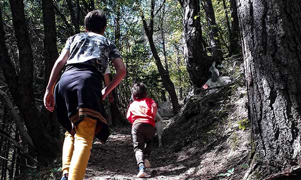 Mamma e bambino camminano nella natura di spalle