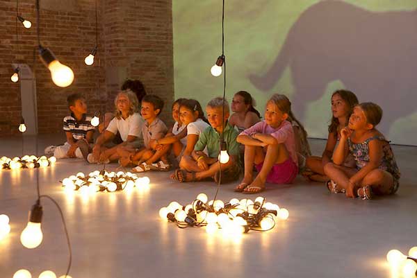 bambini guardano istallazioni di luci