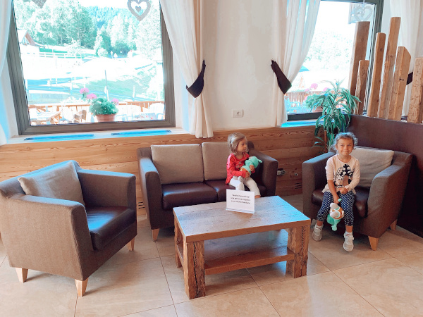 salottino con bimbe sedute sulle poltrone