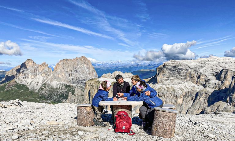 famiglia seduta a un tavolino sulla terrazza delle dolomiti