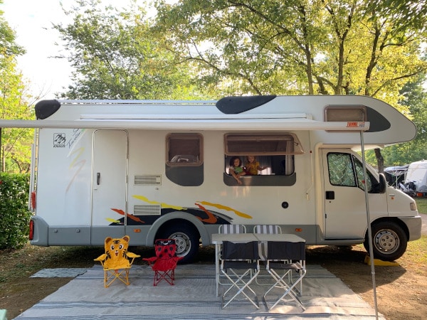 camper in piazzola con tendalino e sedie