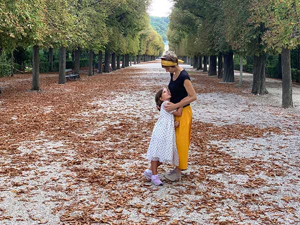 mamma e bambina tra foglie cadute nel parco di Schonbrunn