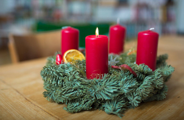 corona di rami d'abete con candele rosse
