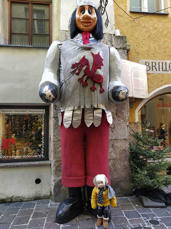 bambina ai piedi di una statua gigante