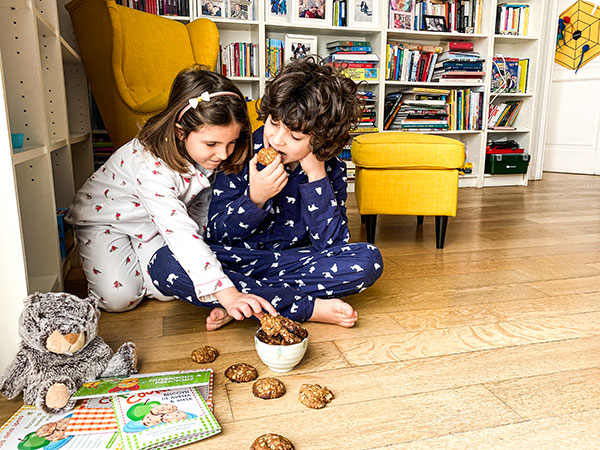 bambini in pigiama mangiano biscotti