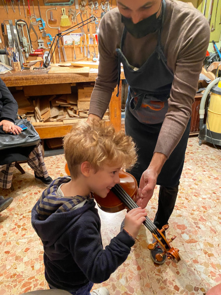 Bambino nella bottega di un liutaio