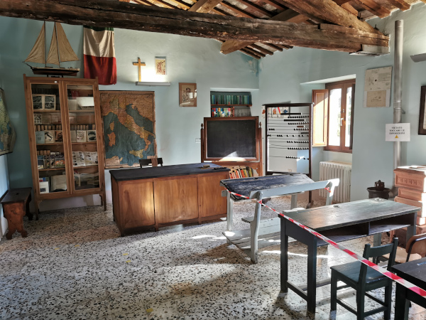 aula di scuola di una volta con banchi, cattedra e lavagna