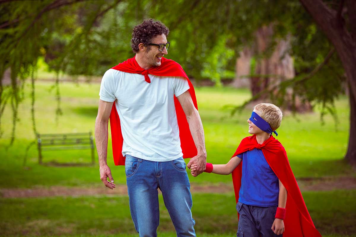 Bambino e papà con mantello da supereroi 