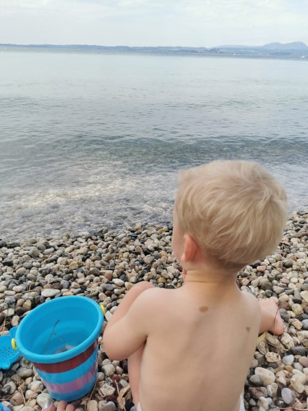 bimbo gioca coi sassi sul lago