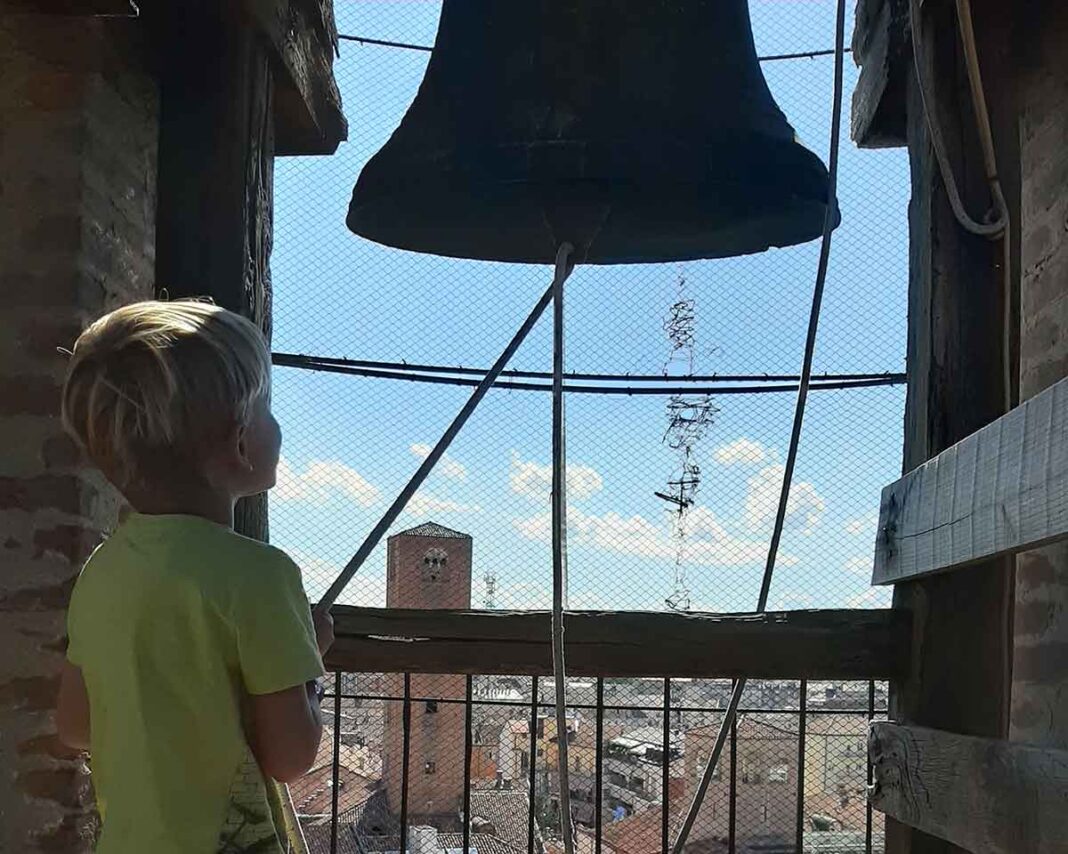 bambino suona la campana sul campanile di Alba
