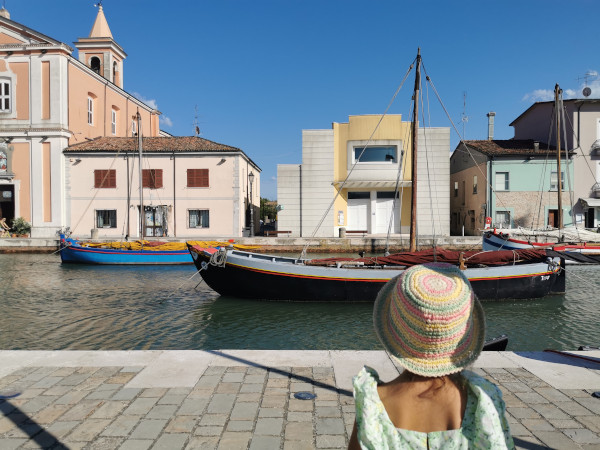 bimba davanti alle barche nel porto canale