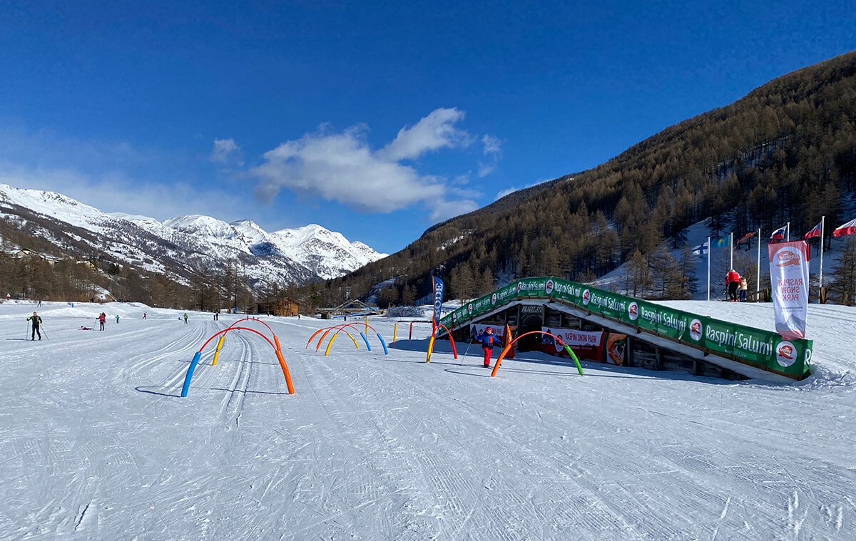 vista del centro del fondo di Pragelato con i giochi per bambini e le montagne innevate 