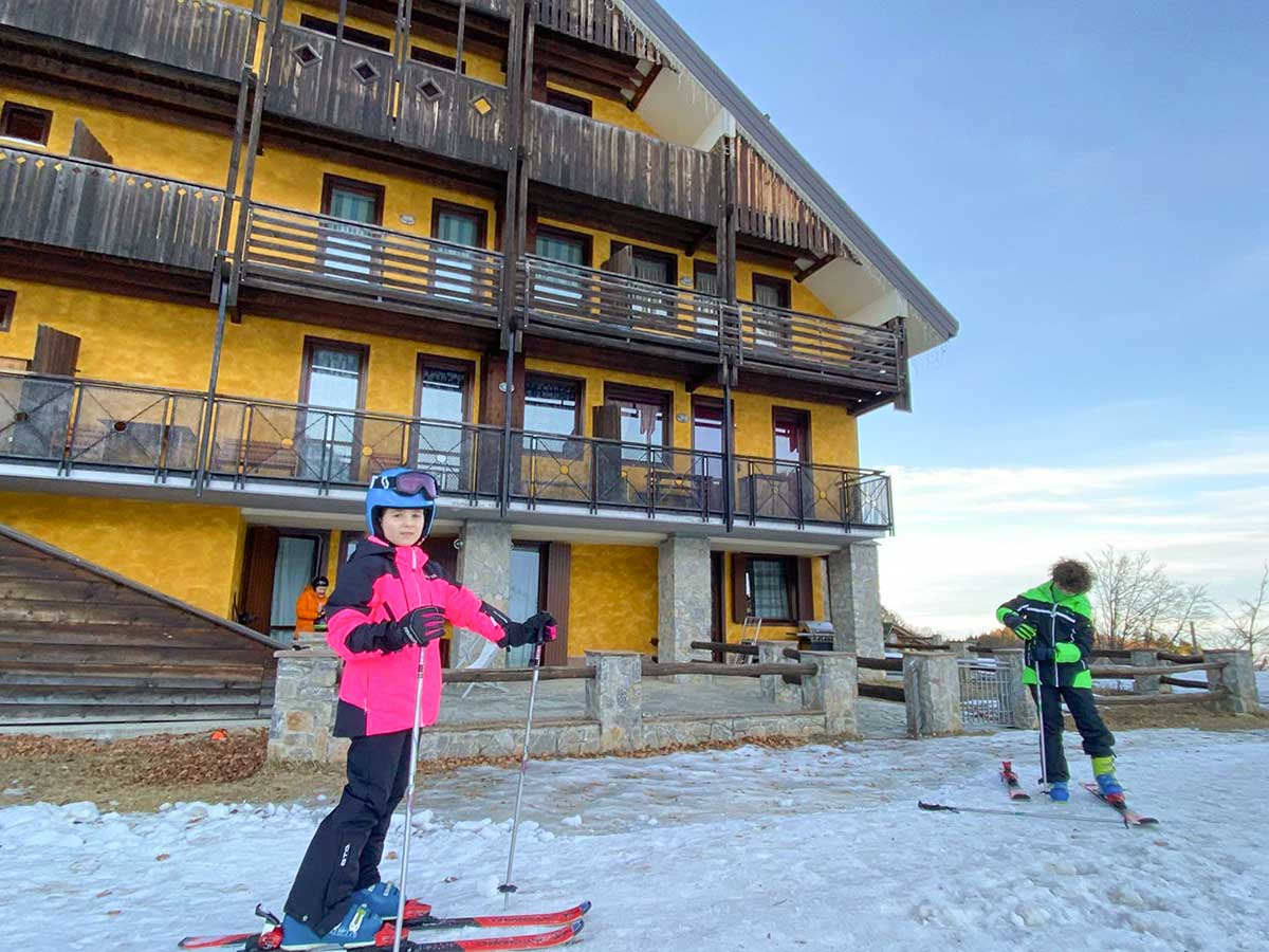 bambini con sci davanti a condominio