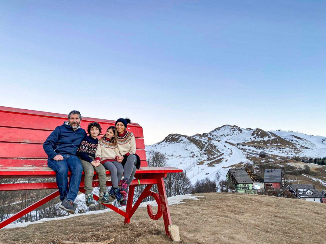 panchina gigante rossa con famiglia