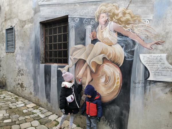 bimbi davanti al murales del pendolo