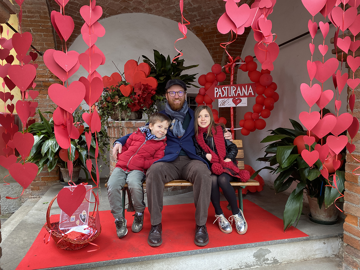 Panchina di San Valentino di Pasturana davanti al pozzo due bambini con il papà