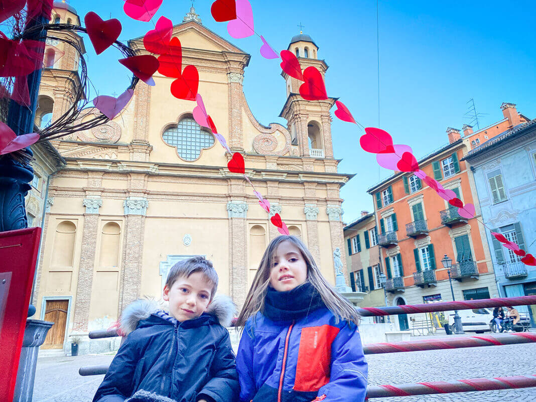 bambini sulla panchina di S Valentino. Sullo sfondo la chiesa