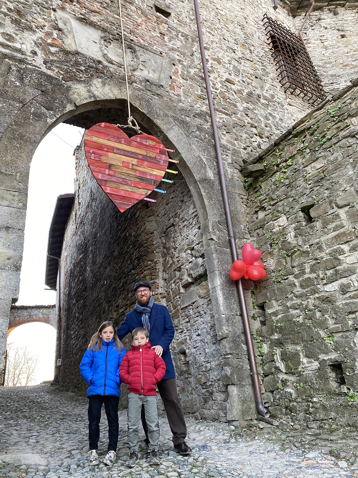 Famiglia sotto la porta del castello addobbata per San Valentino