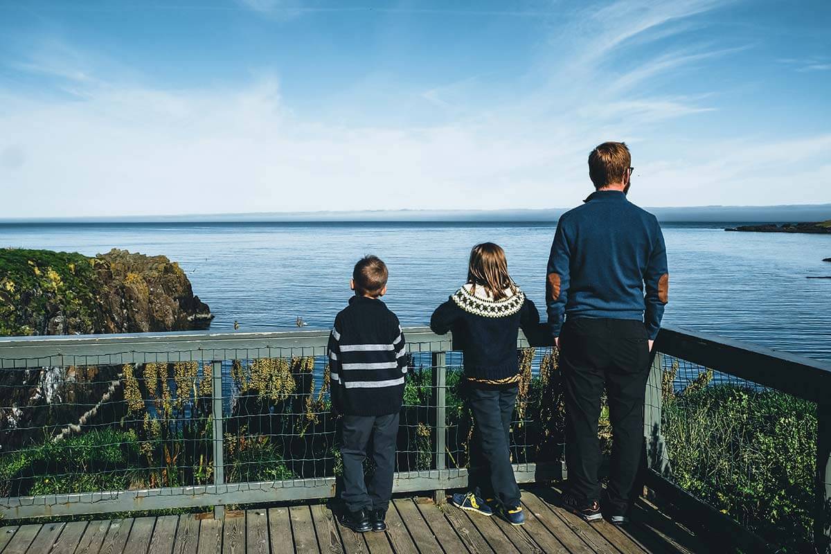 papà con due bambini sul pontile in legno per l'osservazione degli uccelli a Borgarfjördur Eystri