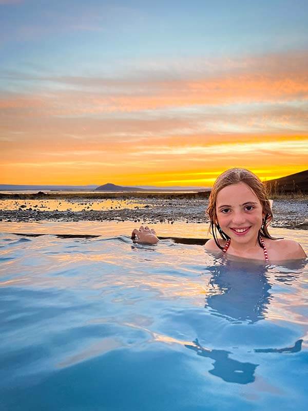 Bambina fa il bagno al tramonto della piscina termale di Mývatn Nature Baths