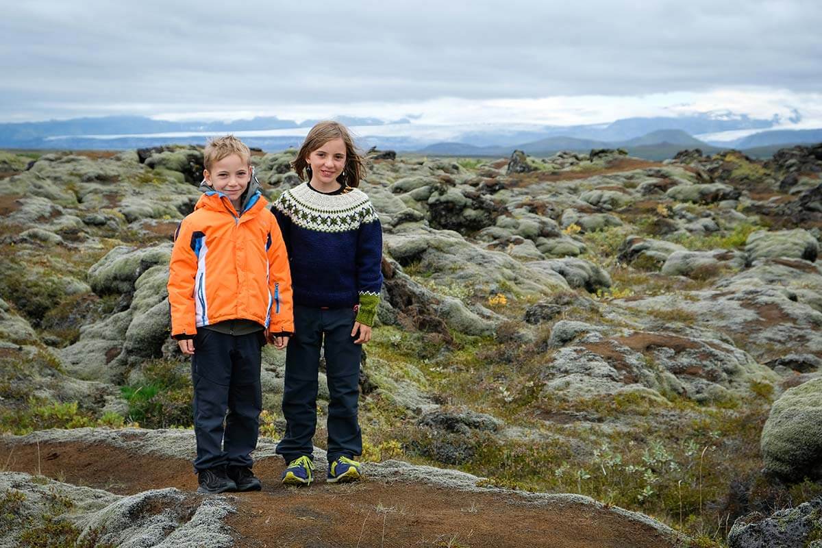 due bambini su un sentiero in un campo di lavo coperto di muschio in Islanda