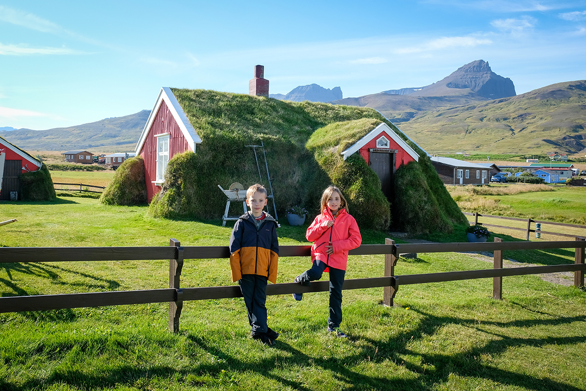 bambini davanti a una casa di torba e erba in Islanda 