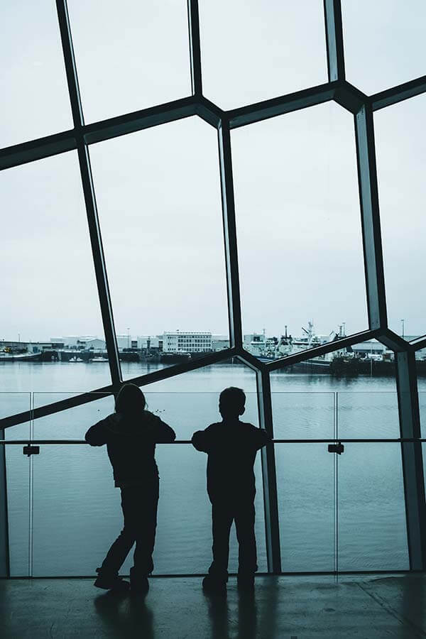 due bambini osservano il porto di Reykjavik dalla vetrata