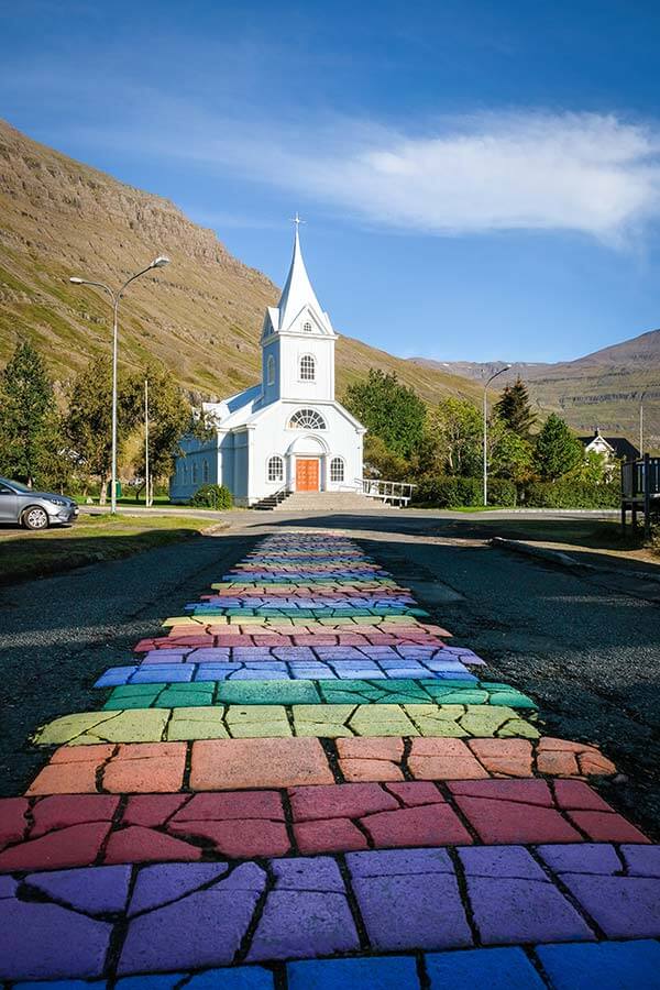 strada arcobaleno a Seydisfjördur con sullo sfondo una chiesa bianca