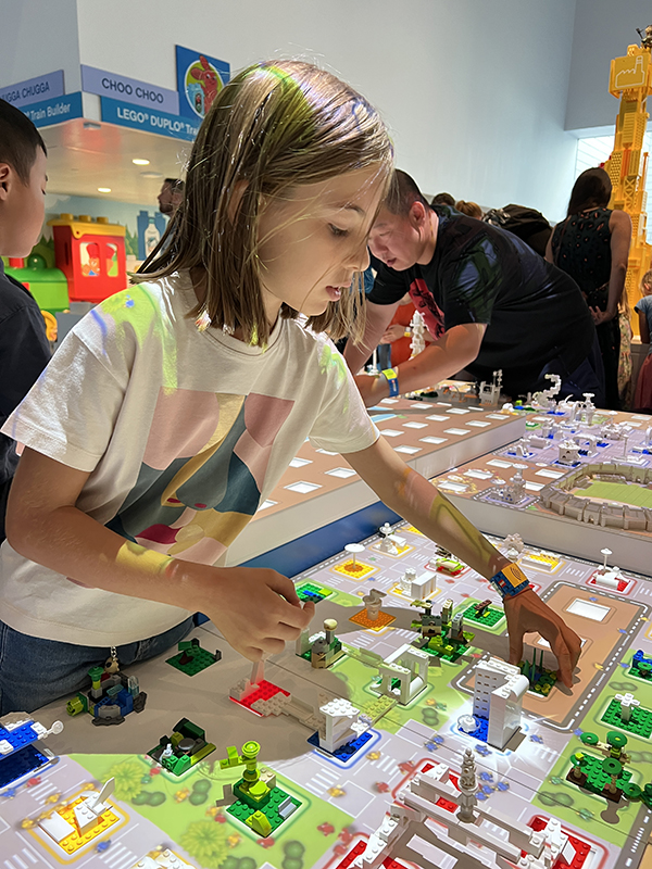 bambina costruisce una città lego interattiva