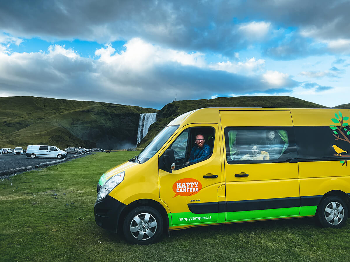 camper giallo davanti alla cascata