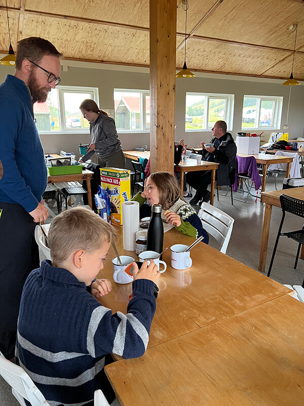 Famiglia che fa colazione in campeggio all'interno