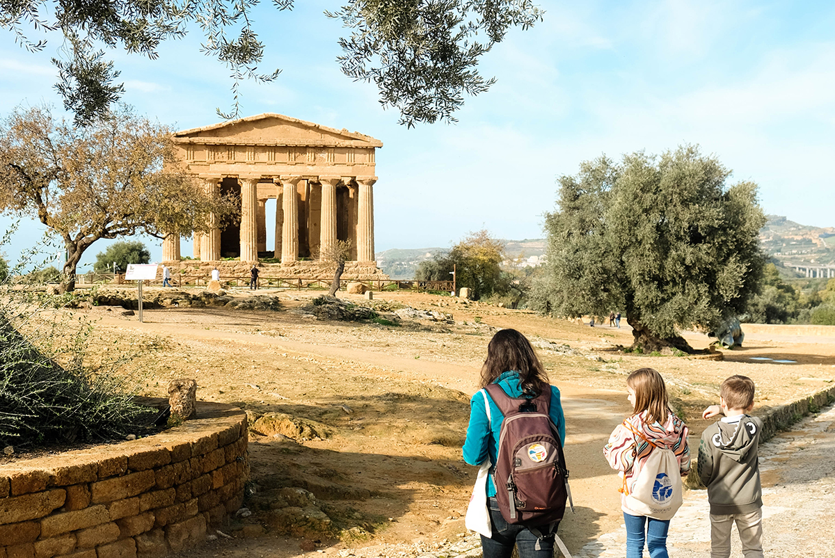bambini e guida camminano verso il tempio della Concordia alla valle dei templi di Agrigento