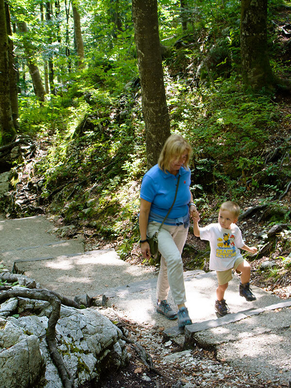 bambino cammina con la nonna nel bosco sul sentiero