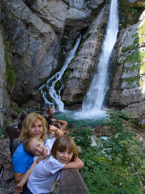bambini con la nonna in posa davanti alla cascata
