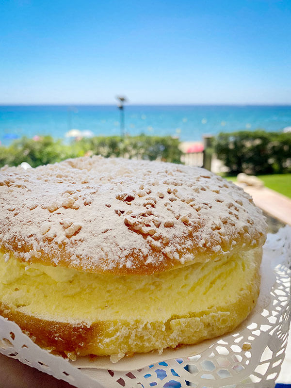 tarte tropezienne e il mare sullo sfondo