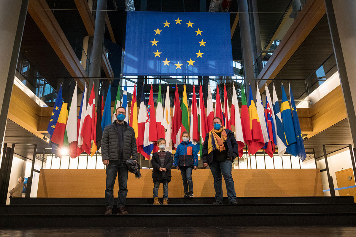 famiglia davanti alle bandiere al parlamento europeo di Strasburgo