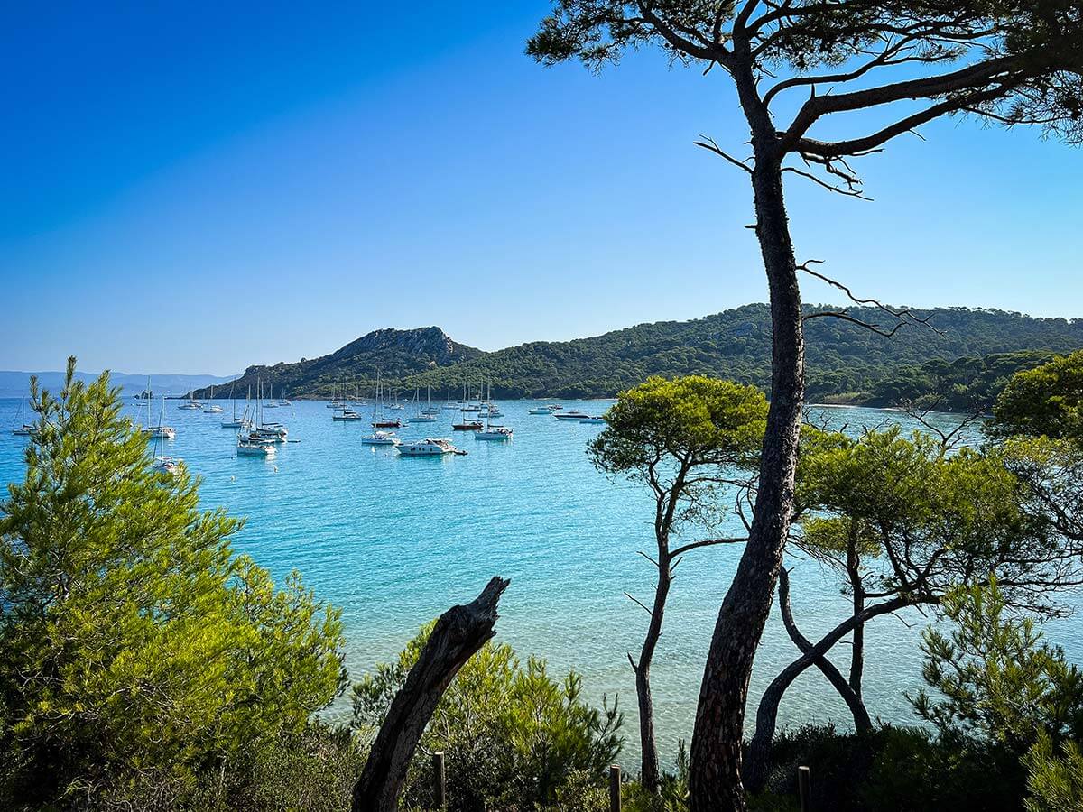 vista della spiaggia Notre Dame a Porquerolles con il mare azzurro e le barche ormeggiate