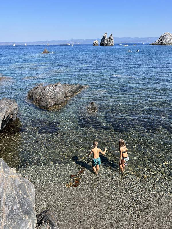 due bambini entrano in acqua nella caletta a Porquerolles