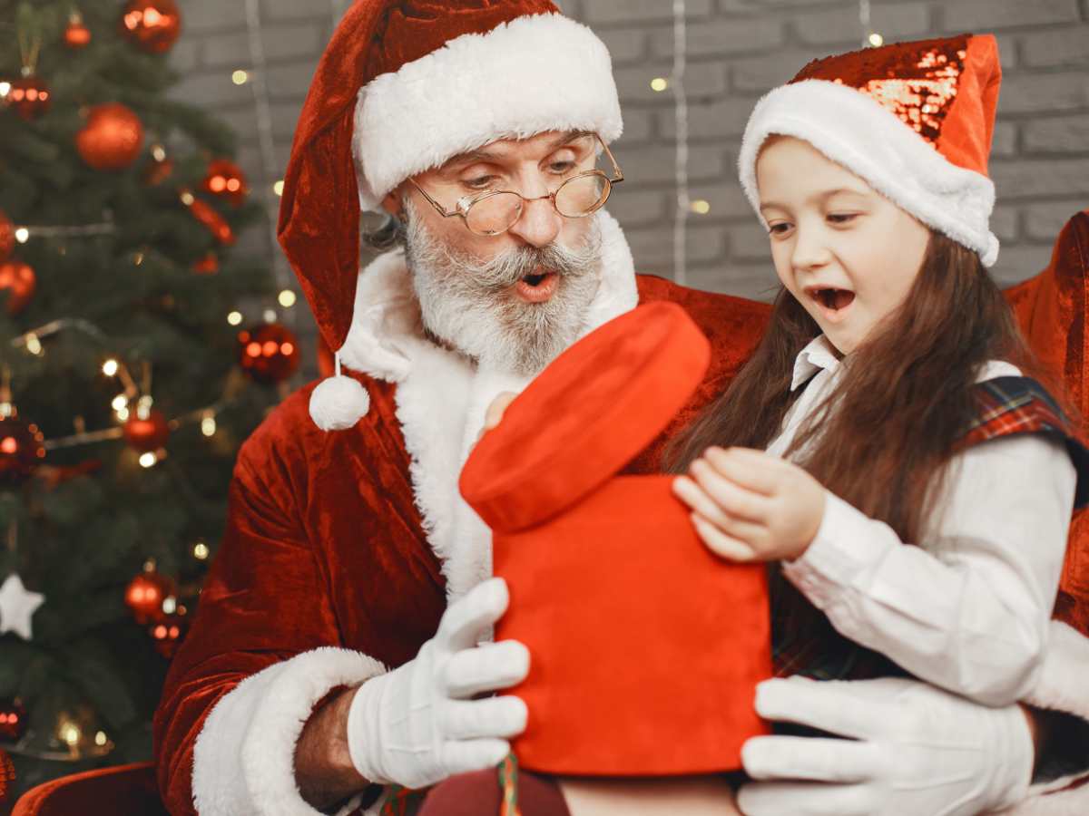 bimba apre regalo nella casa di babbo natale
