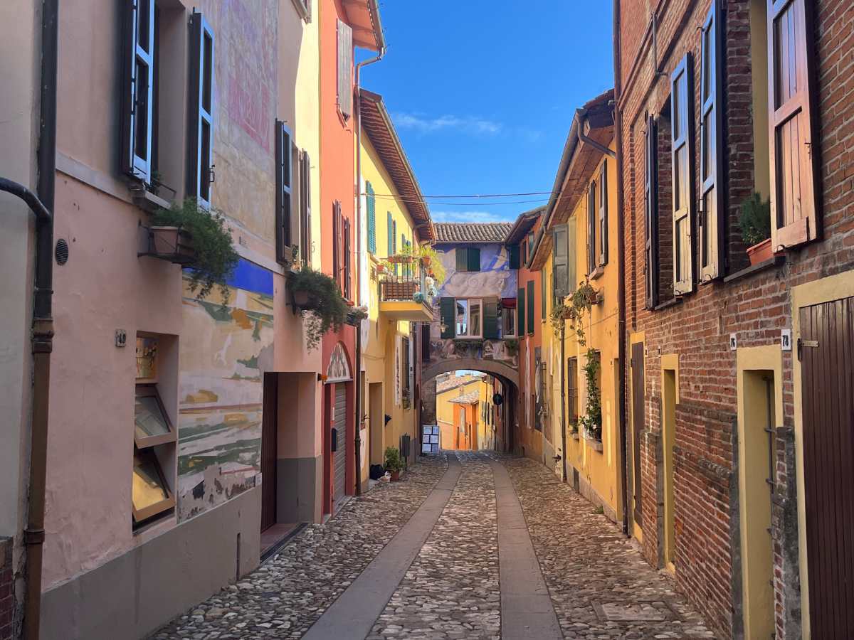 vicolo di dozza con murales sui muri